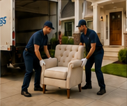Uniformed white-glove delivery team unloading an armchair at a customer’s residence