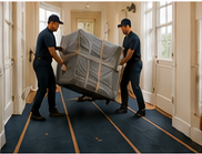 Delivery professionals moving protected furniture across floor runners